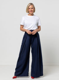 Woman wearing the Nala Woven Pant sewing pattern from Style Arc on The Fold Line. A trousers pattern made in wool or rayon soft suiting, gabardine, twill, linen, or tencel/lyocell fabric, featuring a shaped waistband, zip fly, pleated front, in-seam pockets, and wide leg.