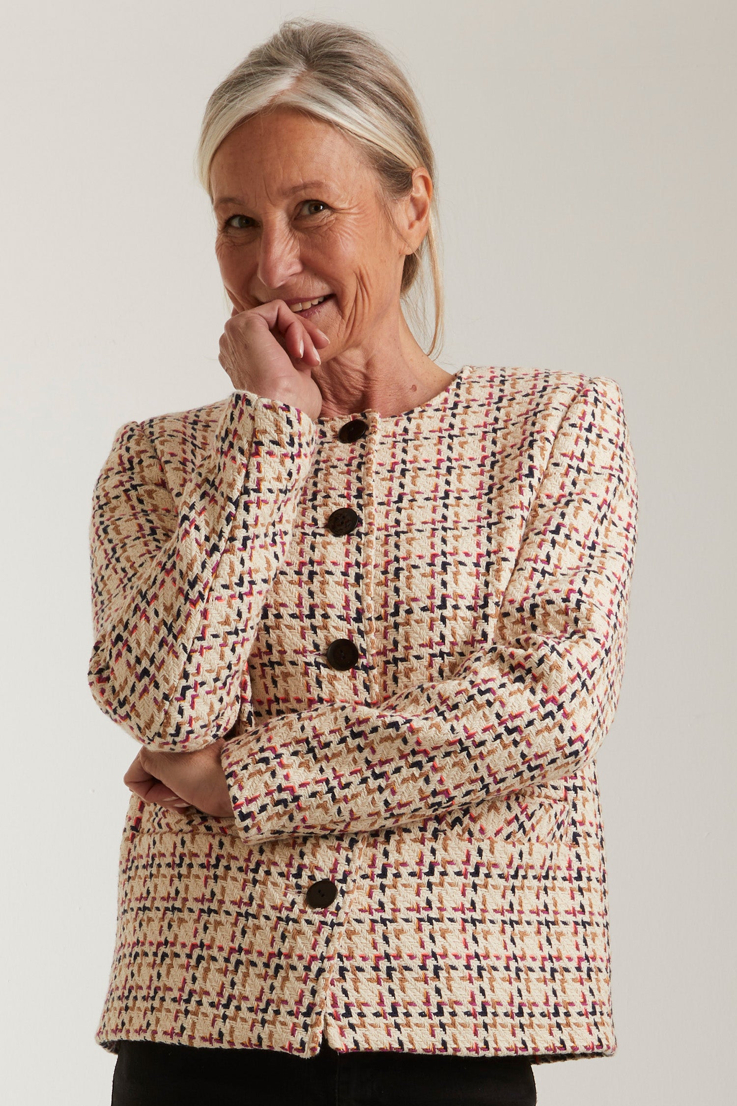 Woman wearing the Nancy Jacket sewing pattern from Coralie Bijasson on The Fold Line. A lined jacket pattern made in tweed, wool, denim, or jacquard fabric, featuring a boxy fit, round neckline, button front, and welt pockets.