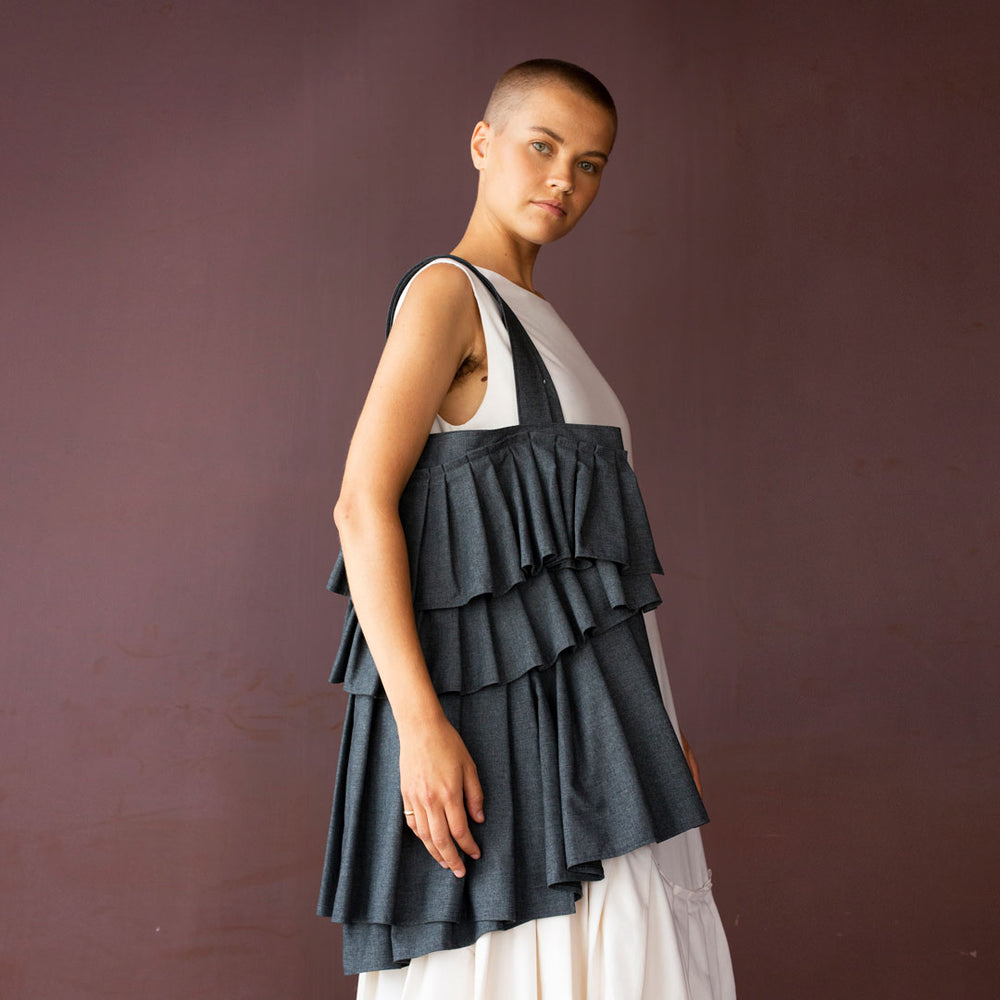 Woman carrying the Naomi Bag sewing pattern from TAUKO on The Fold Line. A tote bag pattern made in medium weight fabric, featuring pleated panels.