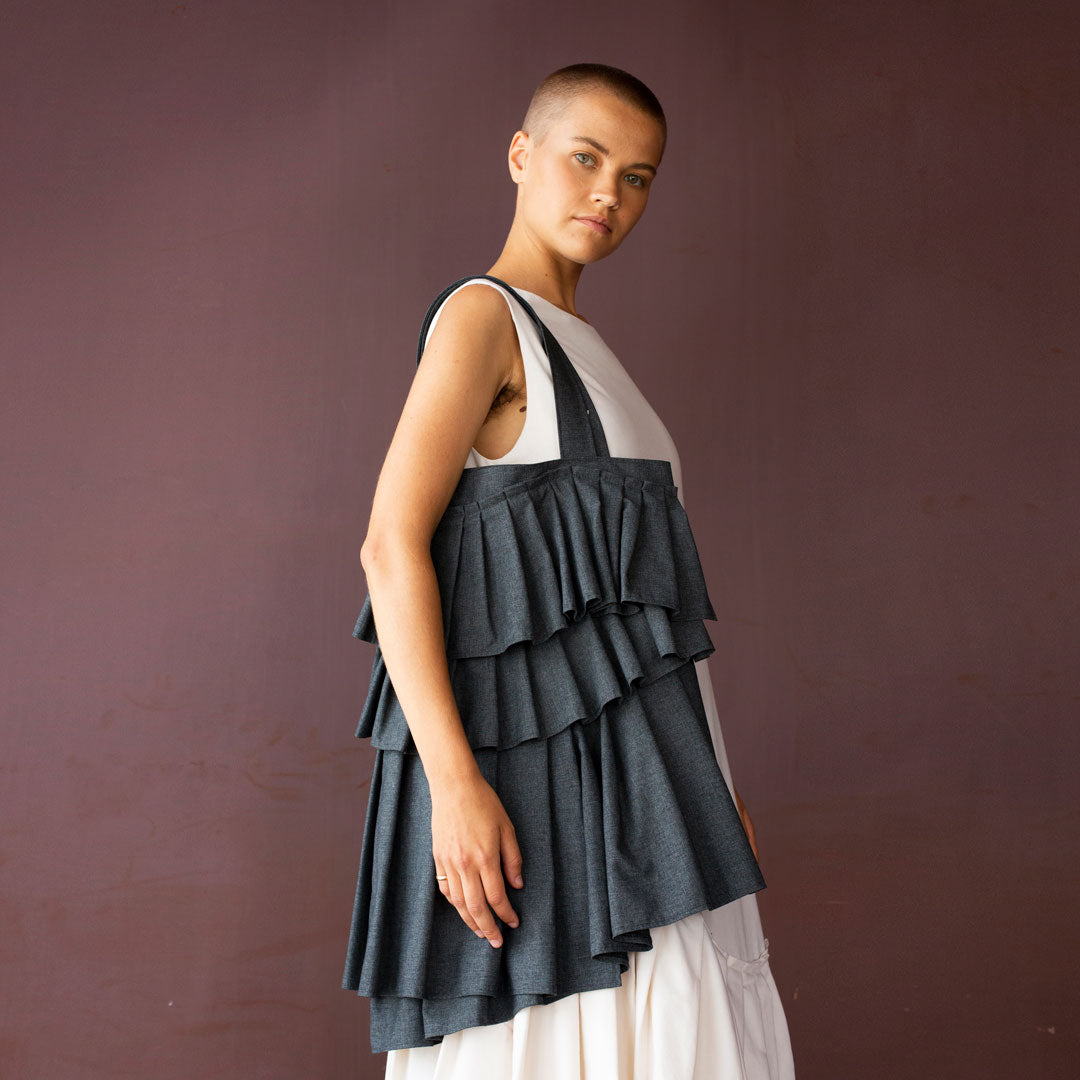 Woman carrying the Naomi Bag sewing pattern from TAUKO on The Fold Line. A tote bag pattern made in medium weight fabric, featuring pleated panels.