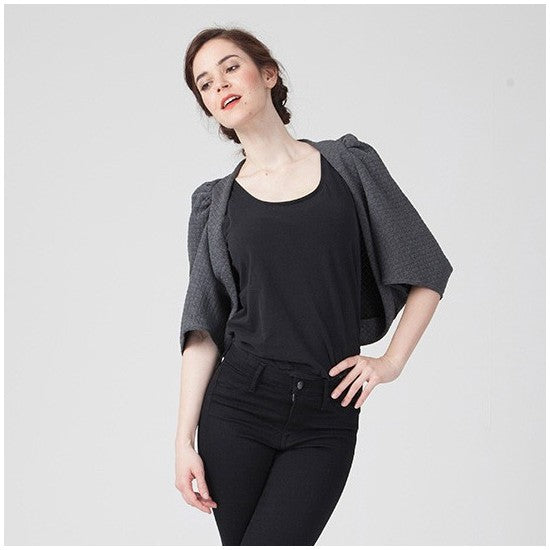 Woman wearing the Naomie Shrug sewing pattern from Coralie Bijasson on The Fold Line. A cropped cardigan pattern made in cotton jersey, viscose jersey, stretch lace, wool knit, or sweatshirt fleece fabric, featuring gathers at the shoulders and mid length sleeves.
