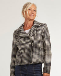 Woman wearing the Napoli Jacket sewing pattern from Coralie Bijasson on The Fold Line. A biker jacket pattern made in tweed, wool, denim, jacquard, or faux leather fabric, featuring an asymmetric zip closure and welt pockets.