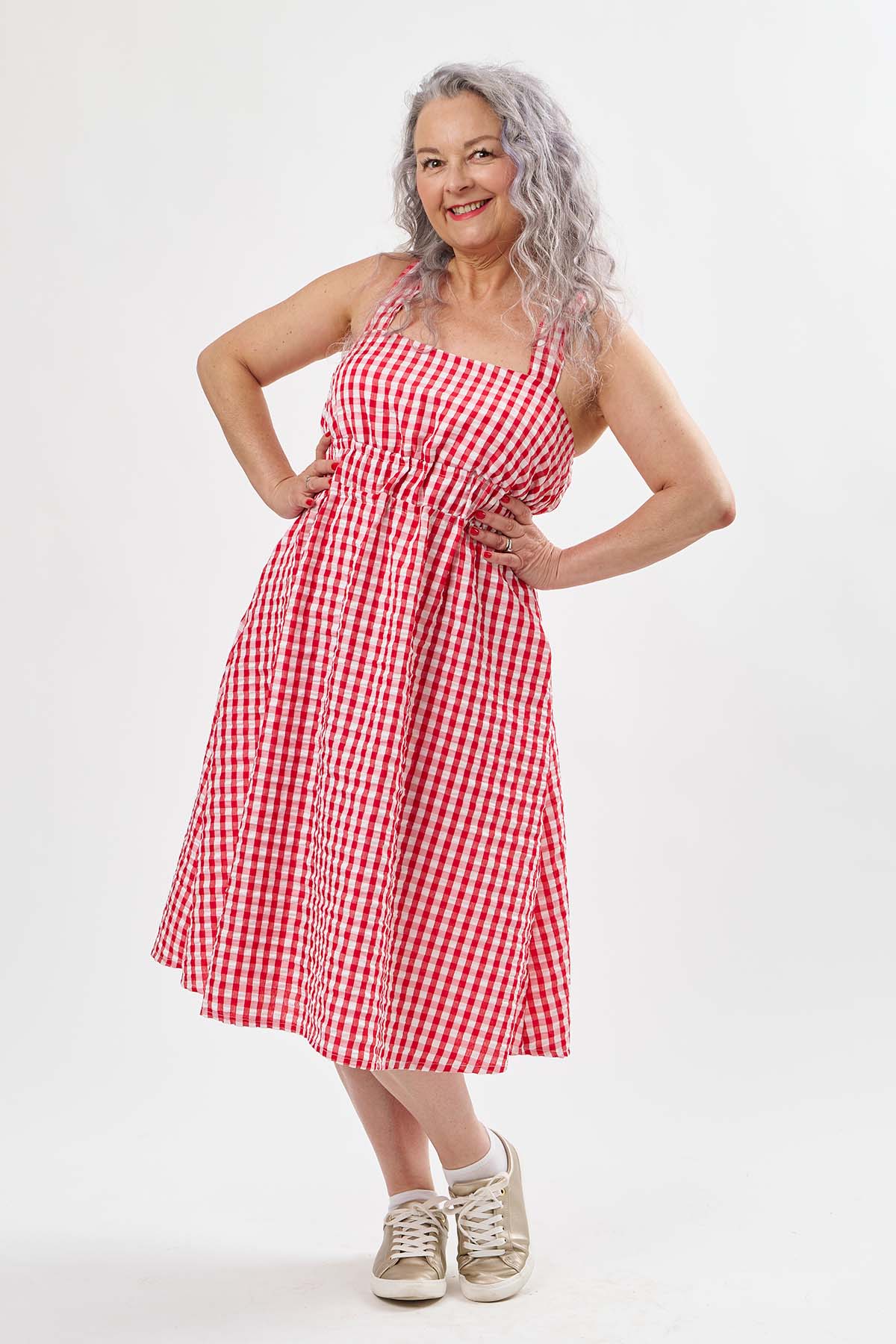 Woman wearing the Natalia Dress sewing pattern from Sew Over It on The Fold Line. A sundress pattern made in cotton, cotton poplin, viscose, linen, viscose linen, crepe, or chambray fabric, featuring wide straps, elastic channels at the waist and under the bust, in-seam pockets, and a midi length.