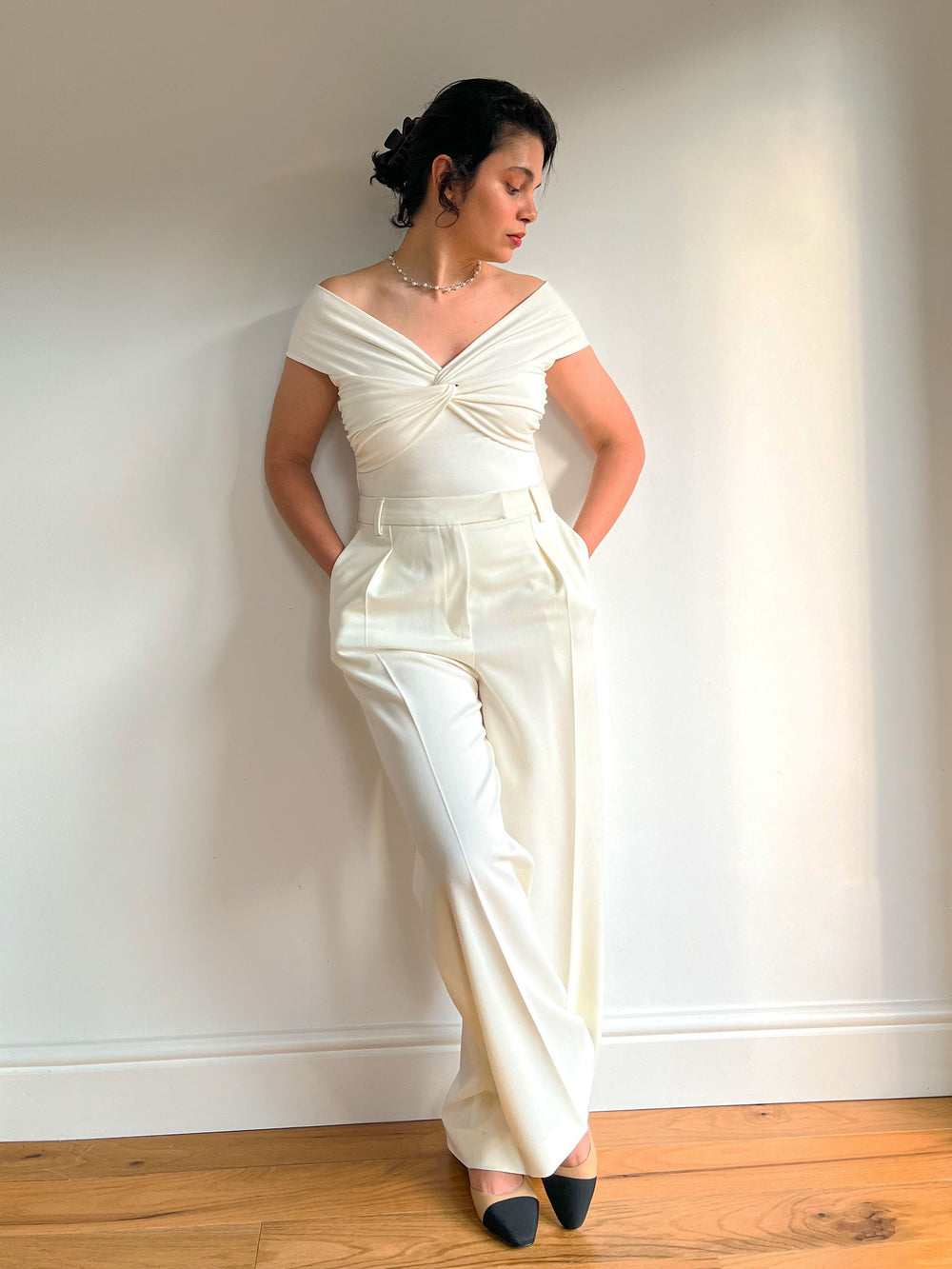 Woman wearing the Neta Trousers sewing pattern from Bella Loves Patterns on The Fold Line. A trousers pattern made in linen or suiting fabric, featuring a high rise, fly front, pleats, pressed crease lines, and side slant pockets.