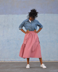 Woman wearing the Neu Skirt sewing pattern from Pauline Alice on The Fold Line. A skirt pattern made in poplin, viscose, nylon, gabardine, or technical fabric, featuring a drawstring cord in front, an elastic waistband in back, and cargo pockets with bellows and flaps.
