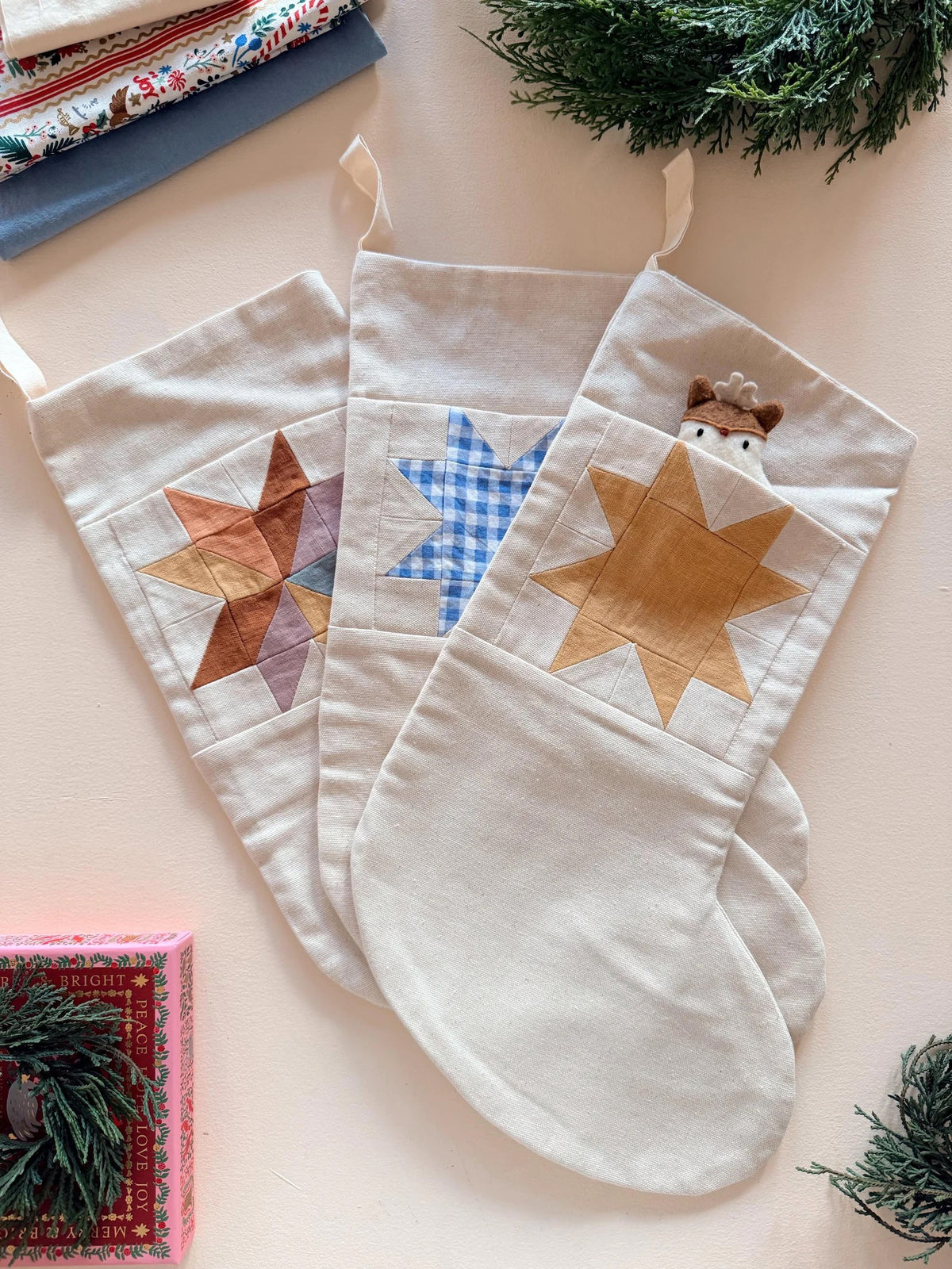 The Nicholas Stocking sewing pattern from Me & Kiddo Patterns on The Fold Line. A fully lined Christmas stocking pattern made in cotton or linen fabric, featuring a patchwork star and pocket.