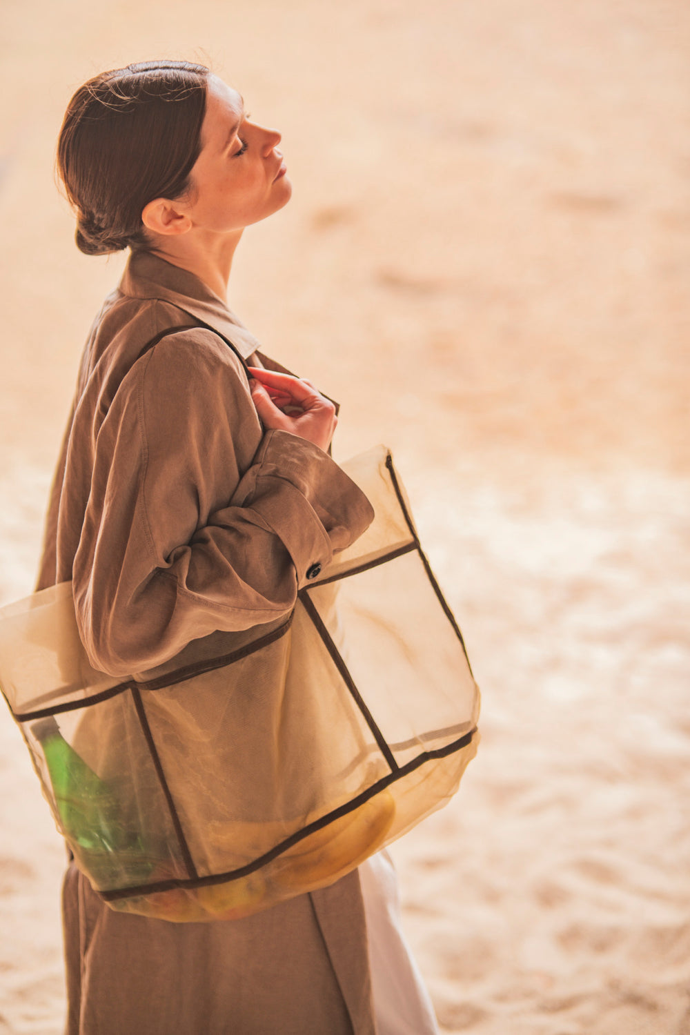 Woman carrying the Nico Bag sewing pattern from Fibre Mood on The Fold Line. A tote bag pattern made in canvas, denim, jute, or firm tulle fabric, featuring pockets on the outside.