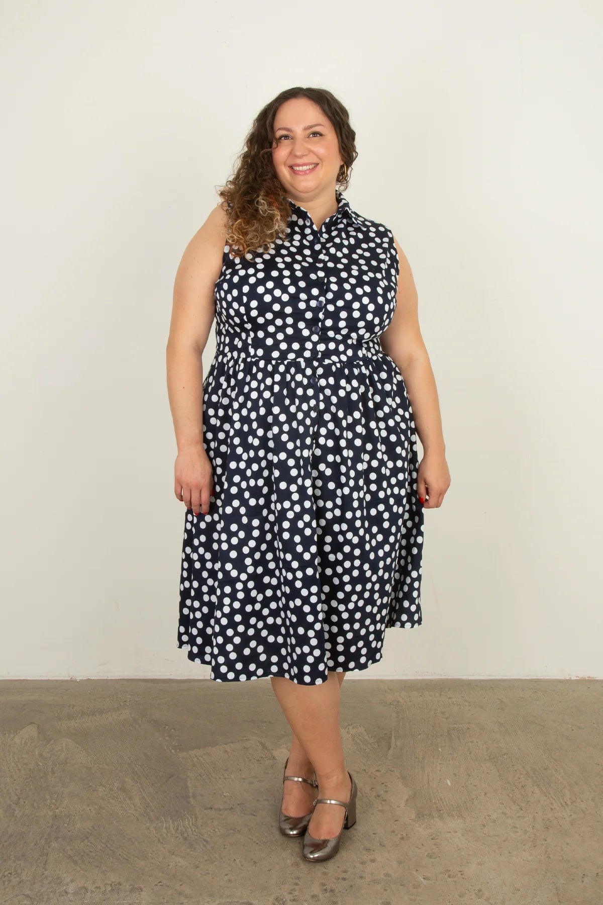 Woman wearing the Nicole Dress Sleeveless Add-on sewing pattern from Sew Over It on The Fold Line. A sleeveless shirt dress pattern made in cotton poplin, cotton lawn, crepe, viscose, or tencel fabric, featuring a collar and collar stand, button front, and below knee length.