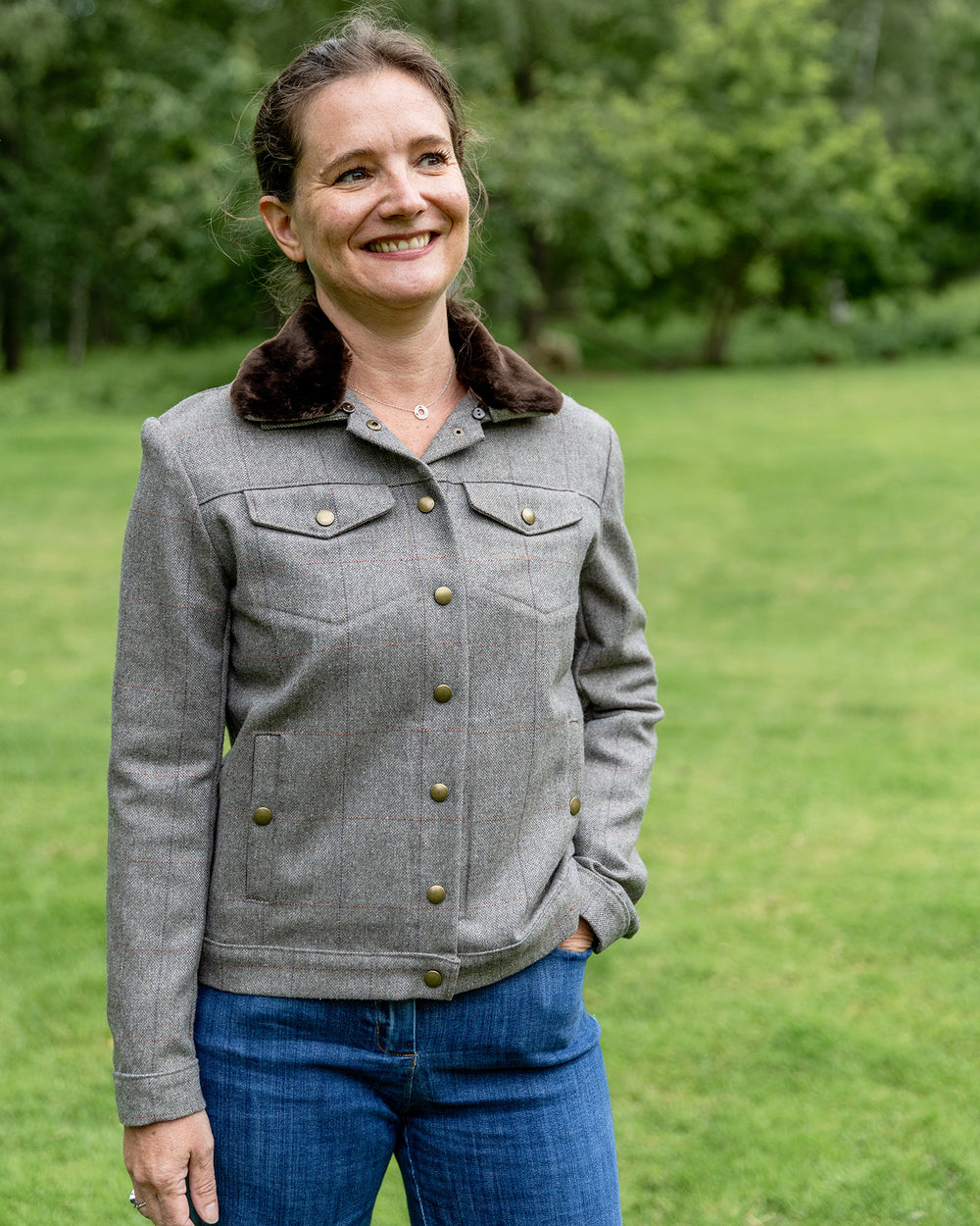 Woman wearing the Nicoletta Jacket sewing pattern from Coralie Bijasson on The Fold Line. A jacket pattern made in cotton satin, denim, wool, gabardine, jacquard, or corduroy fabric, featuring a removable faux fur collar, snap button front, and welt and flap pockets.