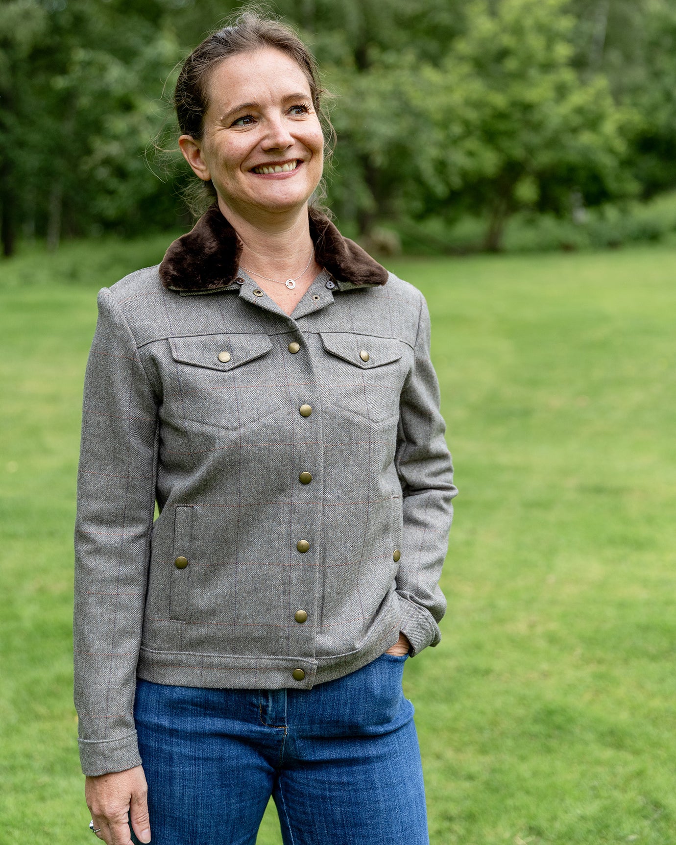 Woman wearing the Nicoletta Jacket sewing pattern from Coralie Bijasson on The Fold Line. A jacket pattern made in cotton satin, denim, wool, gabardine, jacquard, or corduroy fabric, featuring a removable faux fur collar, snap button front, and welt and flap pockets.