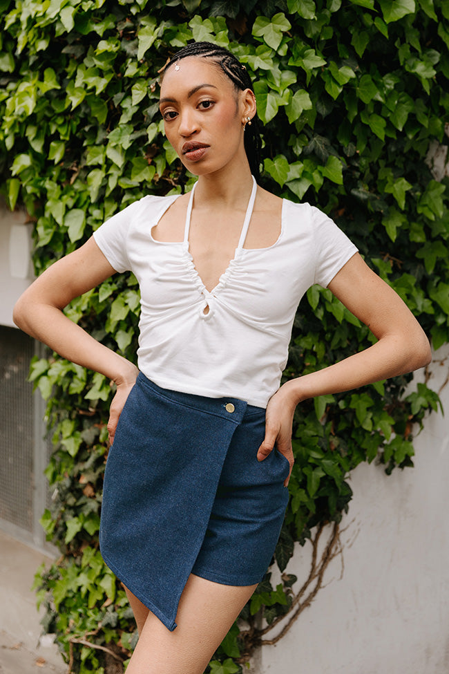 Woman wearing the Nika Skort sewing pattern from JULIANA MARTEJEVS on The Fold Line. A skort pattern made in cotton denim fabric, featuring side and back pockets and a slanted wrap-over skirt panel.