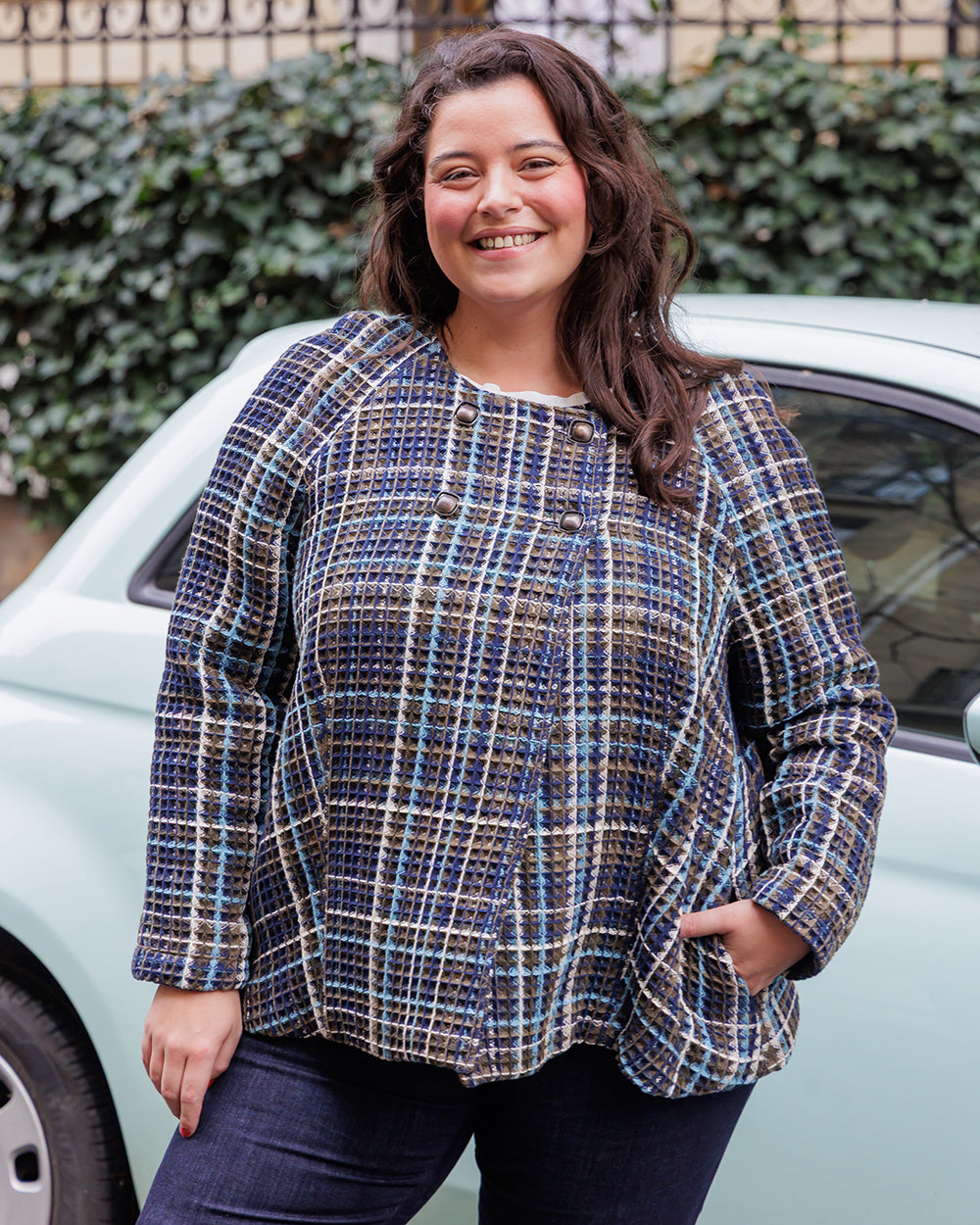Woman wearing the Nine Jacket sewing pattern from Coralie Bijasson on The Fold Line. A double-breasted jacket pattern made in soft wool fabric, featuring a slightly flared silhouette, round neckline, raglan sleeves, and side seam pockets. 