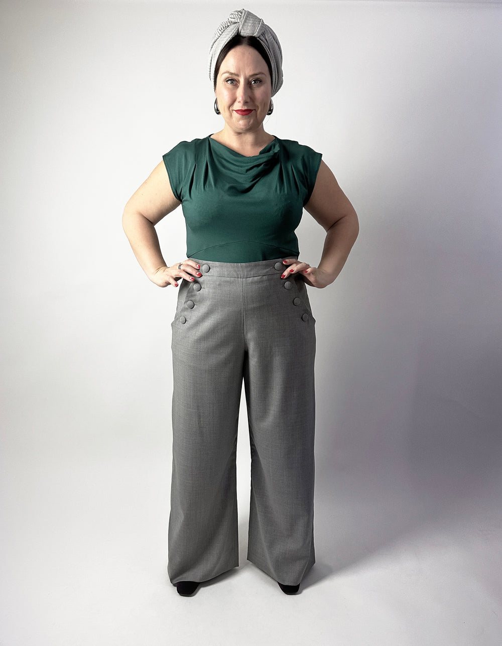 Woman wearing the No. 32 Porto Trousers sewing pattern from How to Do Fashion on The Fold Line. A 1940s-inspired trousers pattern made in cotton, silk, wool, viscose, cupro, linen, or polyester fabric, featuring a curved waistband, sailor style front button closure, wide legs, and pockets.
