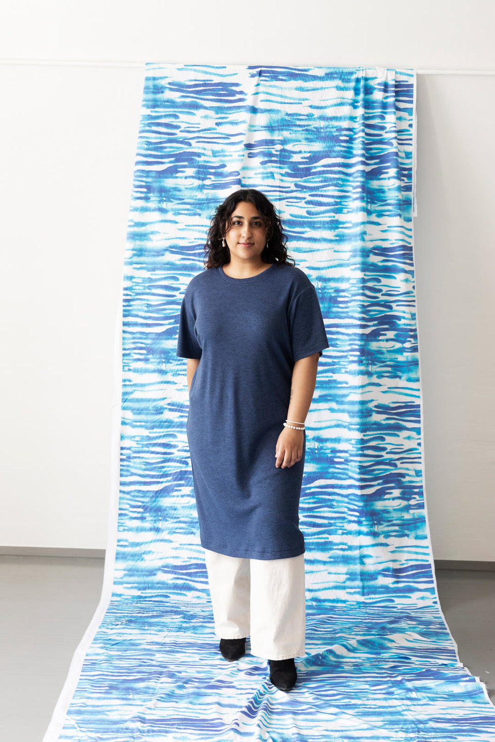 Woman wearing the Nordic Dress sewing pattern from TAUKO on The Fold Line. A dress pattern made in knit or jersey fabric, featuring a relaxed fit, round neckline, and elbow length sleeves.