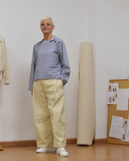 Woman wearing the Onda Shirt sewing pattern from Pauline Alice on The Fold Line. A top pattern made in poplin, linen, lightweight denim, twill, corduroy, or lightweight wool fabric, featuring a relaxed fit, square neckline with a collar, horizontal buttoning on the front, a pocket, and long sleeves.