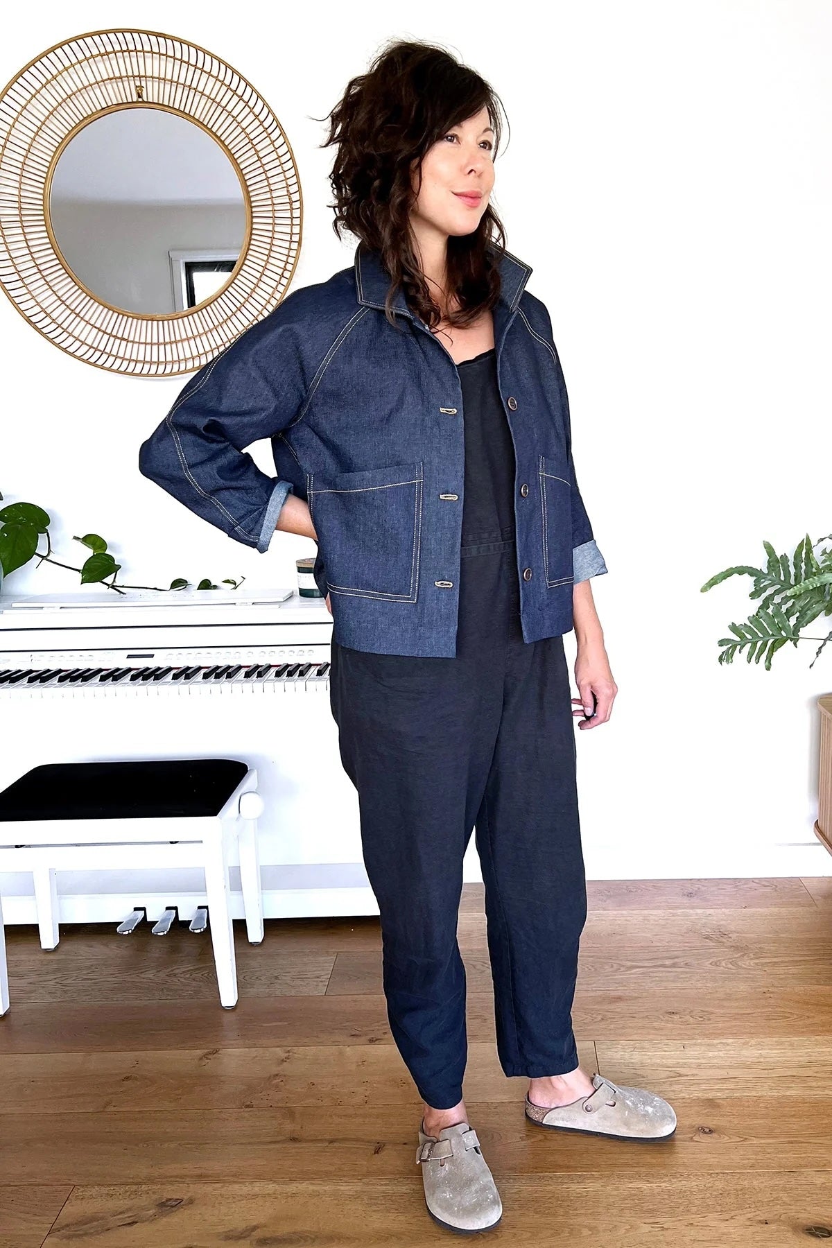 Woman wearing the Ormond Coat sewing pattern from In the Folds on The Fold Line. A jacket pattern made in cotton canvas, waxed canvas, cotton moleskin, rigid denim, corduroy, or heavyweight cotton drill fabric, featuring a boxy silhouette, convertible collar, long raglan sleeves, front button closure, patch pockets, and contrast topstitching.