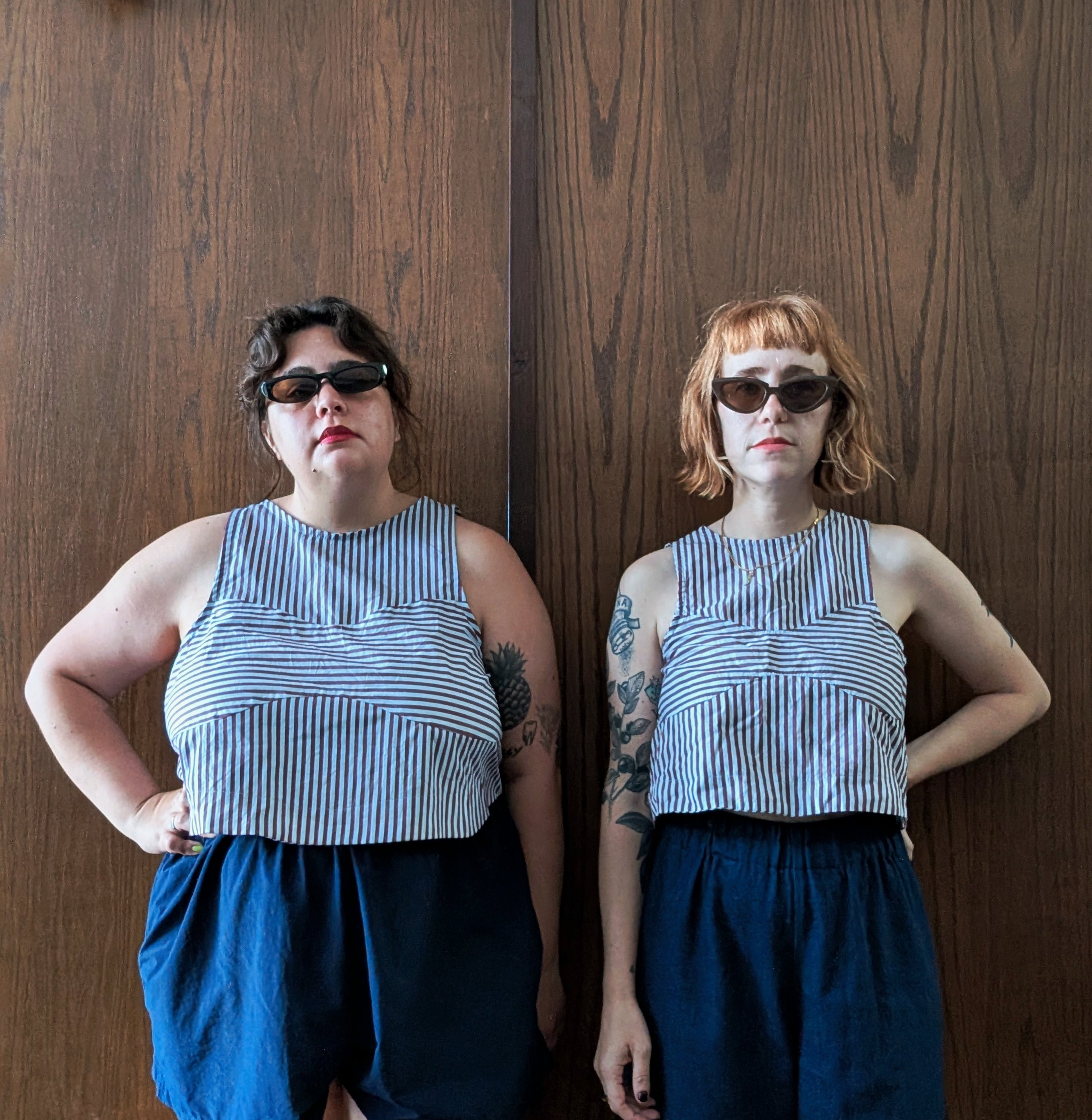 Women wearing the Ornella Top sewing pattern from Spaghetti Western Sewing on The Fold Line. A sleeveless top pattern made in light to mid weight woven fabric, featuring a round neck, scooped armscye, bralette-shaped cutout, and cropped length.
