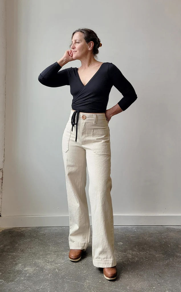 Woman wearing the Oxbow Pants sewing pattern from Sew House Seven on The Fold Line. A pants pattern made in bull denim, denim, twill, corduroy, or canvas fabric, featuring a high rise, curved waistband, patch pockets, zipper fly, and straight semi-wide legs.