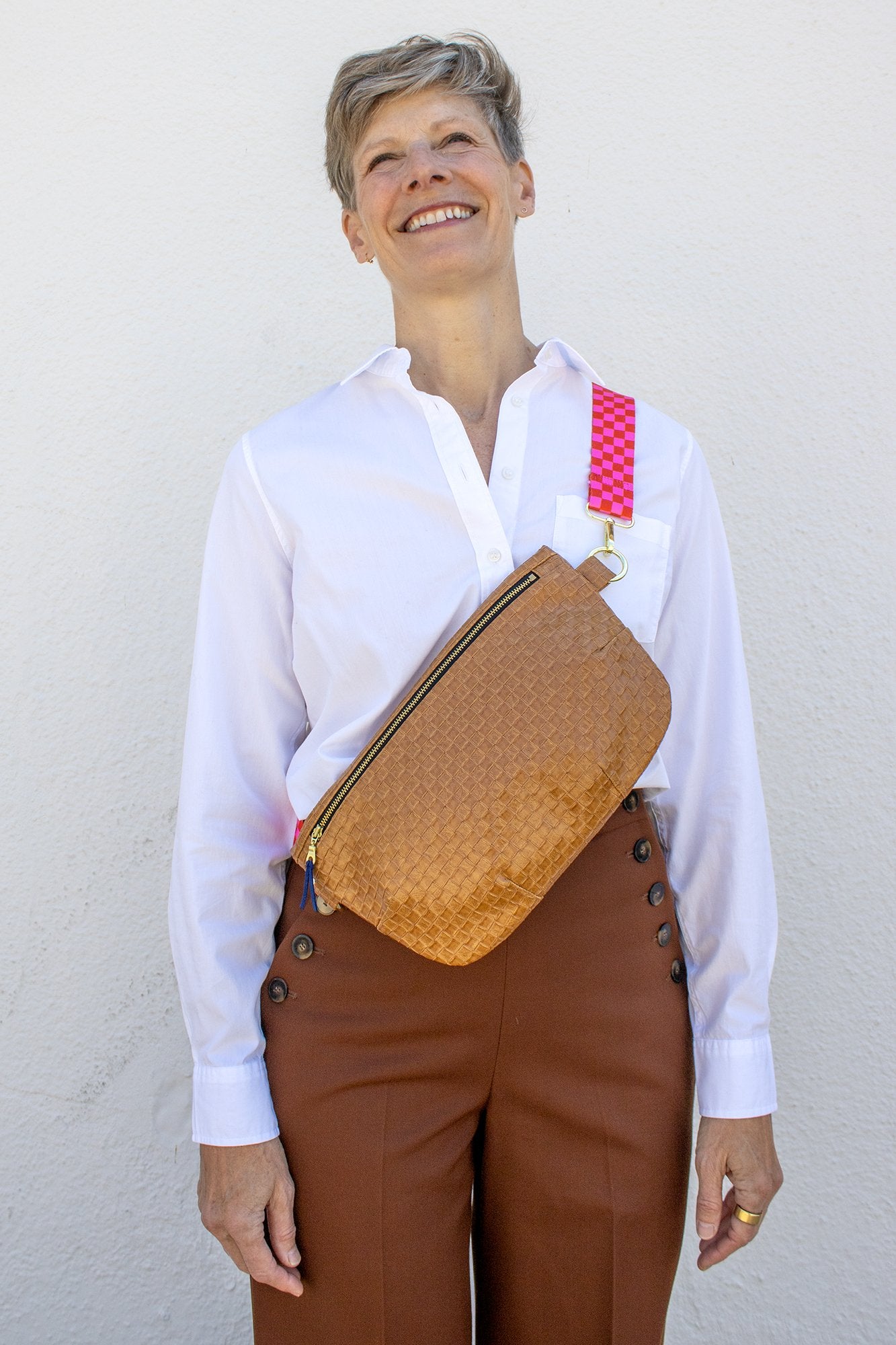 Woman wearing the Paquette Bag sewing pattern from Christine Haynes on The Fold Line. A cross body bag pattern made in cotton, linen, denim, wool, corduroy, canvas, upholstery, leather, or vinyl fabric, featuring a full lining and zipper closure.
