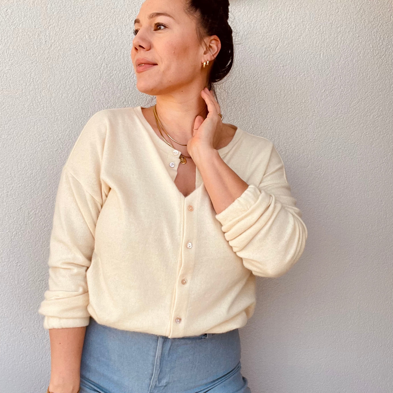 Woman wearing the Paula Cardigan sewing pattern from Sew.lala Patterns on The Fold Line. A cardigan pattern made in cotton jersey, viscose jersey, ponte knit, or lightweight linen knit fabric, featuring a relaxed fit, round neck, button front, and long sleeves with an elasticated cuff.