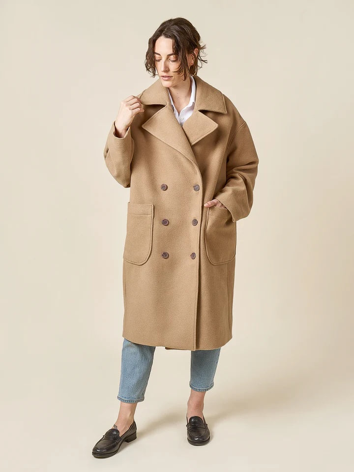 Woman wearing the Phoebe Coat sewing pattern from Closet Core Patterns on The Fold Line. A coat pattern made in melton, bouclé, tweed, felt, or boiled wool fabric, featuring an oversized silhouette, cocoon shape, dropped shoulder, double-breasted front, dramatic notched collar and lapel, two-piece sleeve, patch pockets, below-knee length, and full lining.