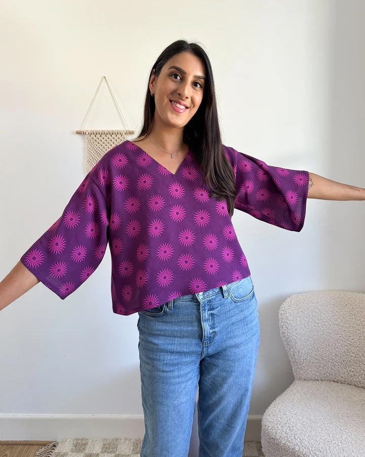 Woman wearing the Phoebe Top sewing pattern from Tammy Handmade on The Fold Line. A top pattern made in cotton, linen, viscose, double gauze, or crepe fabric, featuring a relaxed fit, V-neckline, dropped shoulder, and 3/4 length sleeves.
