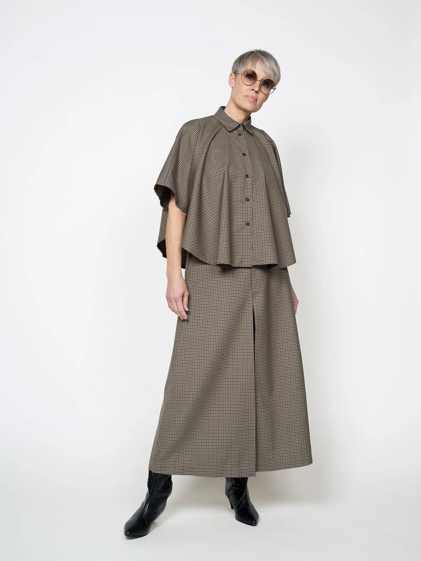 Woman wearing the Poncho Shirt sewing pattern from The Assembly Line on The Fold Line. A shirt pattern made in wool or cotton shirting fabric, featuring a drapey silhouette, collar, and button closure.