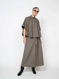 Woman wearing the Poncho Shirt sewing pattern from The Assembly Line on The Fold Line. A shirt pattern made in wool or cotton shirting fabric, featuring a drapey silhouette, collar, and button closure.