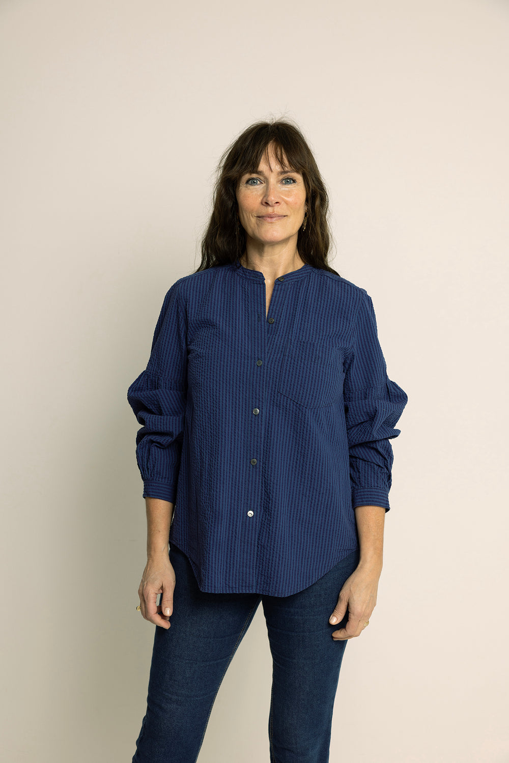 Woman wearing the Puff Shirt sewing pattern from Wardrobe by Me on The Fold Line. A shirt pattern made in cotton or linen fabric, featuring a round neckline, button front, long sleeves with voluminous gathers, and a curved hem.