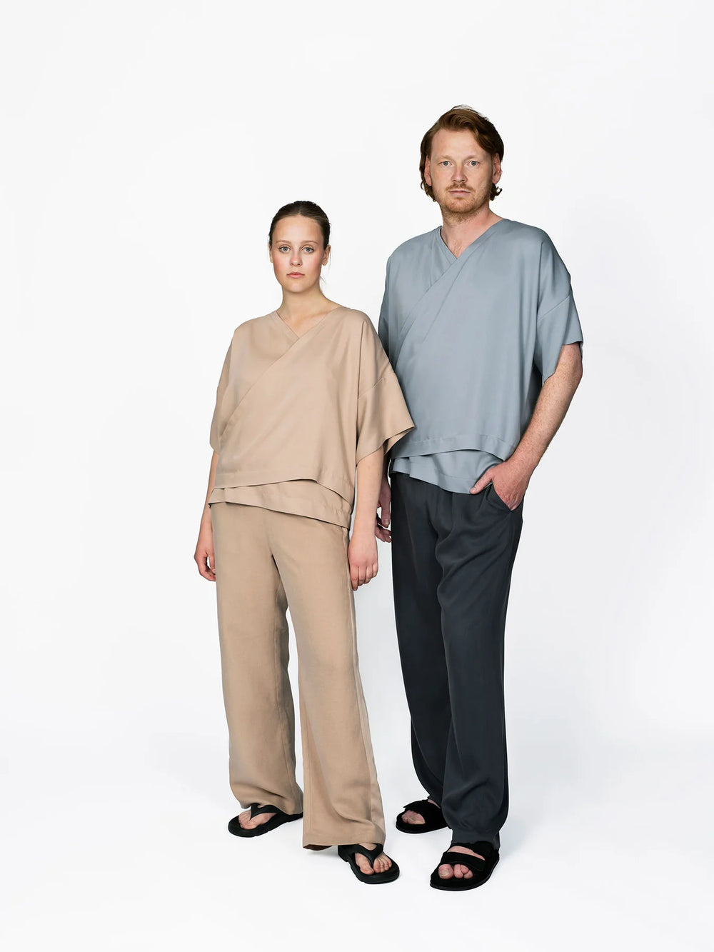 Man and woman wearing the Pull-on Trousers sewing pattern from The Assembly Line on The Fold Line. A trousers pattern made in cotton, linen, viscose, wool, or lightweight twill fabric, featuring an elastic waist and slant pockets.