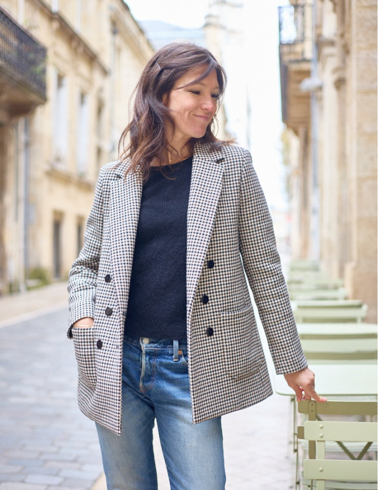 Woman wearing the Punto Blazer sewing pattern from Atelier Scämmit on The Fold Line. A fully lined blazer pattern made in wool or cashmere fabric, featuring a lapel collar, bust darts, double-breasted closure, curved tailored sleeves, patch pockets, and a back vent. 