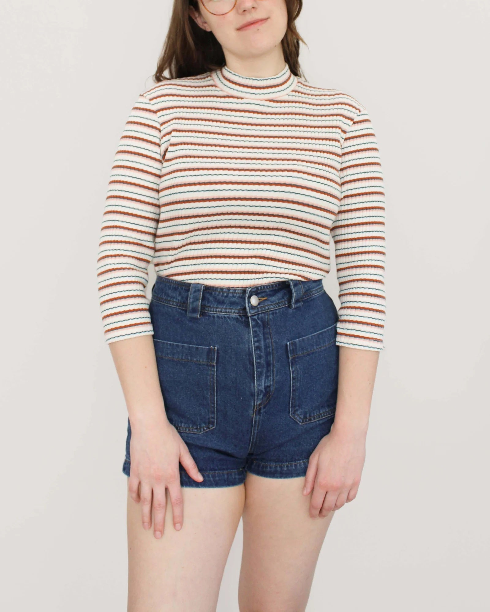 Woman wearing the Ramona Top sewing pattern from Oh Me Oh My Sewing on The Fold Line. A top pattern made in knit fabric, featuring a mock neck and 3/4 length sleeves. 