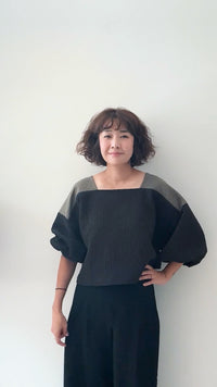 Woman wearing the Rectangle Top sewing pattern from Sewing Therapy on The Fold Line. A blouse pattern made in poplin, cotton lawn, broadcloth, chambray, rayon, viscose, tencel, linen, jacquard, lightweight wool, double gauze, cotton voile, or seersucker fabric, featuring a square neckline and sleeves with elastic cuffs.