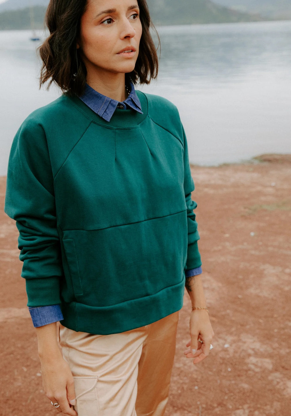 Woman wearing the Ressac Sweatshirt sewing pattern from Maison Fauve on The Fold Line. A sweatshirt pattern made in jersey, French terry, or sweater knit fabric, featuring a relaxed fit, raglan sleeves, front neckline darts, ribbed side panels, and pockets.