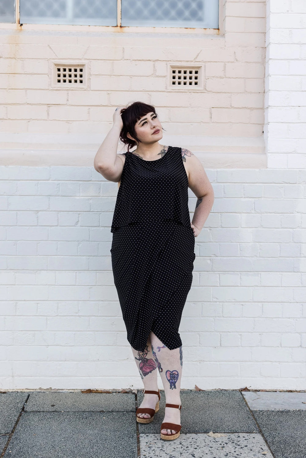 Woman wearing the Reznor Skirt sewing pattern from Elbe Textiles on The Fold Line. A skirt pattern made in knit fabric, featuring a fitted silhouette, high elastic waist, angled box pleat, asymmetrical hemline, and below knee length.
