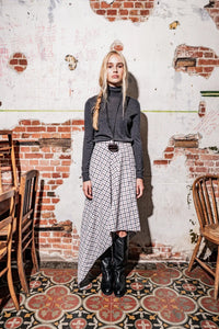 Woman wearing the Ria Skirt sewing pattern from Fibre Mood on The Fold Line. A skirt pattern made in cotton, gabardine, twill, denim, or light wool fabric, featuring an asymmetrical silhouette.