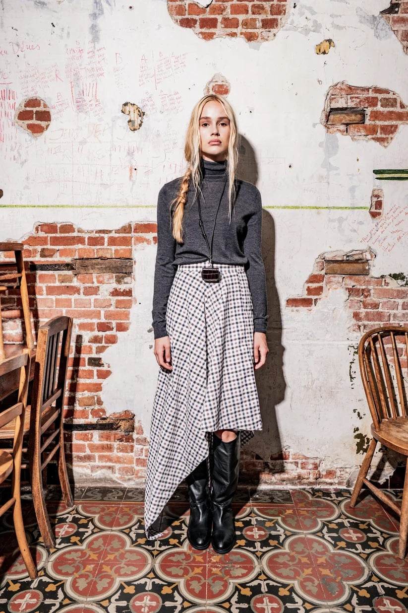 Woman wearing the Ria Skirt sewing pattern from Fibre Mood on The Fold Line. A skirt pattern made in cotton, gabardine, twill, denim, or light wool fabric, featuring an asymmetrical silhouette.