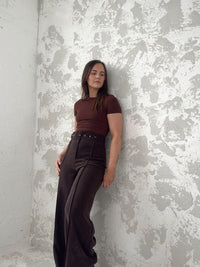 Woman wearing the Riviera Trousers sewing pattern from NH Patterns on The Fold Line. A trousers pattern made in modal, tencel, or suiting fabric, featuring a wide waistband, belt, fly front, pintuck detail, and wide legs.