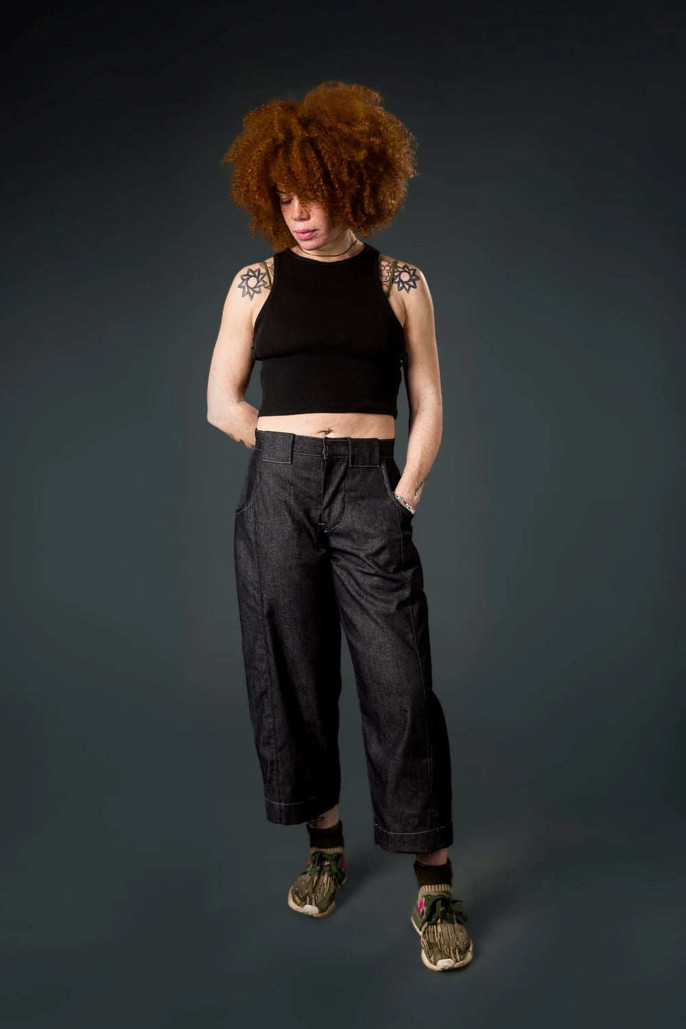 Woman wearing the Roan Trousers sewing pattern from Emporia Patterns on The Fold Line. A pants pattern made in denim, linen, needlecord, drill, cotton twill, or canvas fabric, featuring a medium rise waist, zip fly, cutaway front pockets, a back yoke, back patch pockets, barrel leg, and topstitching.