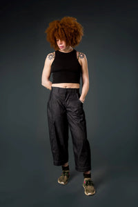 Woman wearing the Roan Trousers sewing pattern from Emporia Patterns on The Fold Line. A pants pattern made in denim, linen, needlecord, drill, cotton twill, or canvas fabric, featuring a medium rise waist, zip fly, cutaway front pockets, a back yoke, back patch pockets, barrel leg, and topstitching.