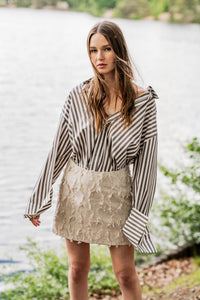 Woman wearing the Rosemary Skirt sewing pattern from Fibre Mood on The Fold Line. A skirt pattern made in cotton twill, denim, leather, velvet, poplin, polycotton, linen, or woven jacquard fabric, featuring darts at the front and back, subtle A-line shape, waist facing, back zip, and mini length.