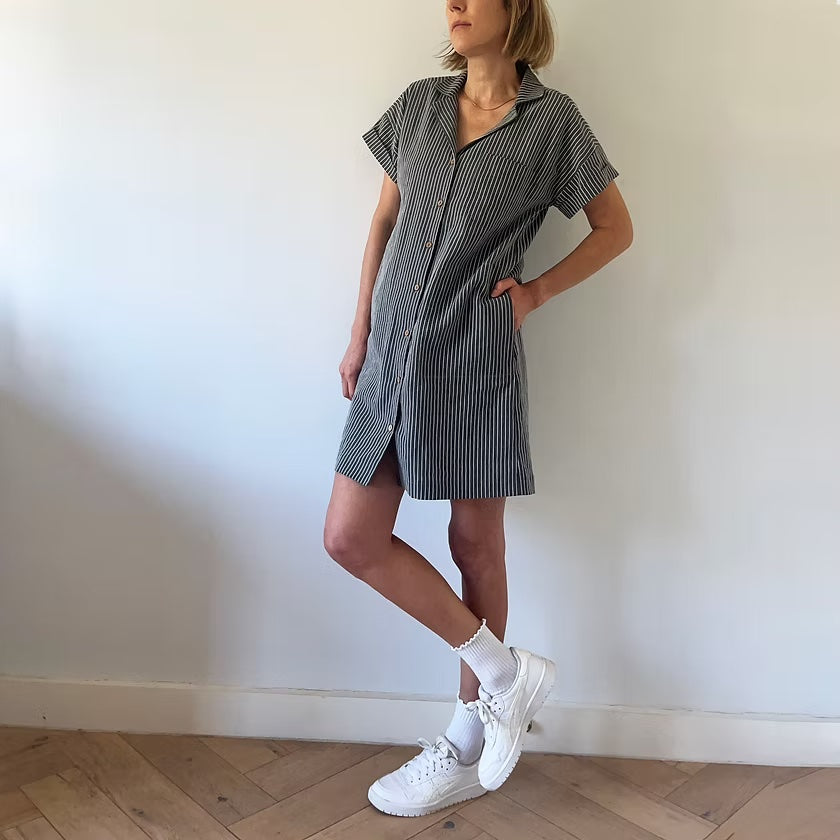 Woman wearing the Rothko Dress and Shirt sewing pattern from French Navy on The Fold Line. A shirt dress pattern made in viscose, rayon challis, linen, linen/viscose blend, chambray, cotton, or cotton blend fabric, featuring a notched collar, button front, short sleeves, chest pocket, in-seam side pockets, and mini length.