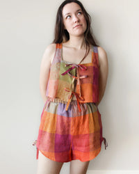 Woman wearing the Ruby Top sewing pattern from Oh Me Oh My Sewing on The Fold Line. A sleeveless top pattern made in quilting cotton, washed linen, viscose, cotton lawn, voile, or rayon challis fabric, featuring a relaxed fit, square neckline, tie front, and cropped length. 