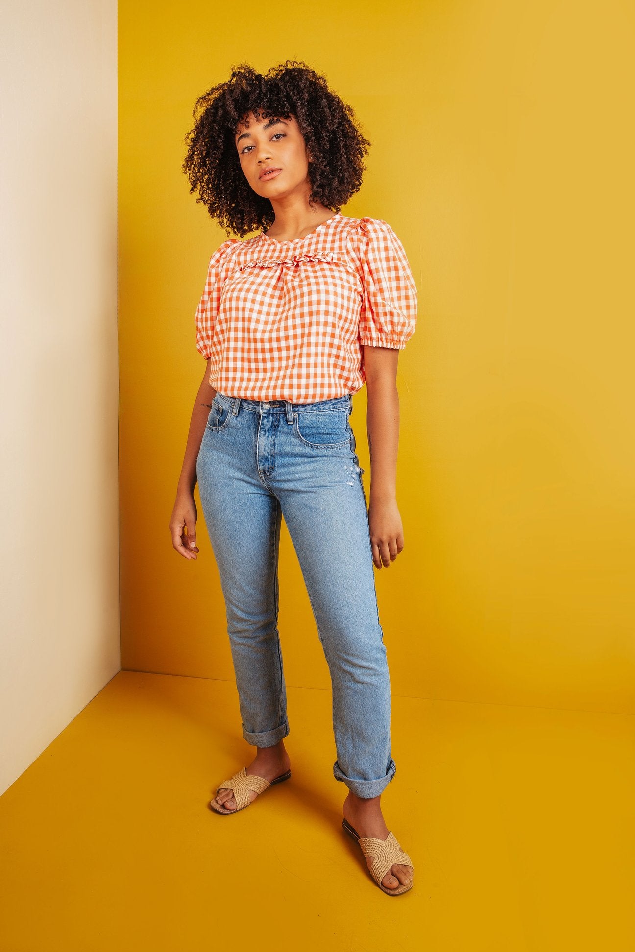 Woman wearing the Sagebrush Top sewing pattern from Friday Pattern Company on The Fold Line. A top pattern made in cotton voile, rayon challis, linen, silk, or cotton shirting fabric, featuring a relaxed fit, round neckline, short puff sleeves, and gathers and a ruffle across the front.