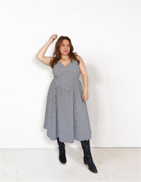 Woman wearing the Sailaway Dress sewing pattern from Les Perlines on The Fold Line. A dress pattern made in rayon, viscose, cotton, linen, or tencel twill fabric, featuring a V-neckline, open back, lined bodice with princess seams, dropped waist, gathered skirt, and midi length. 