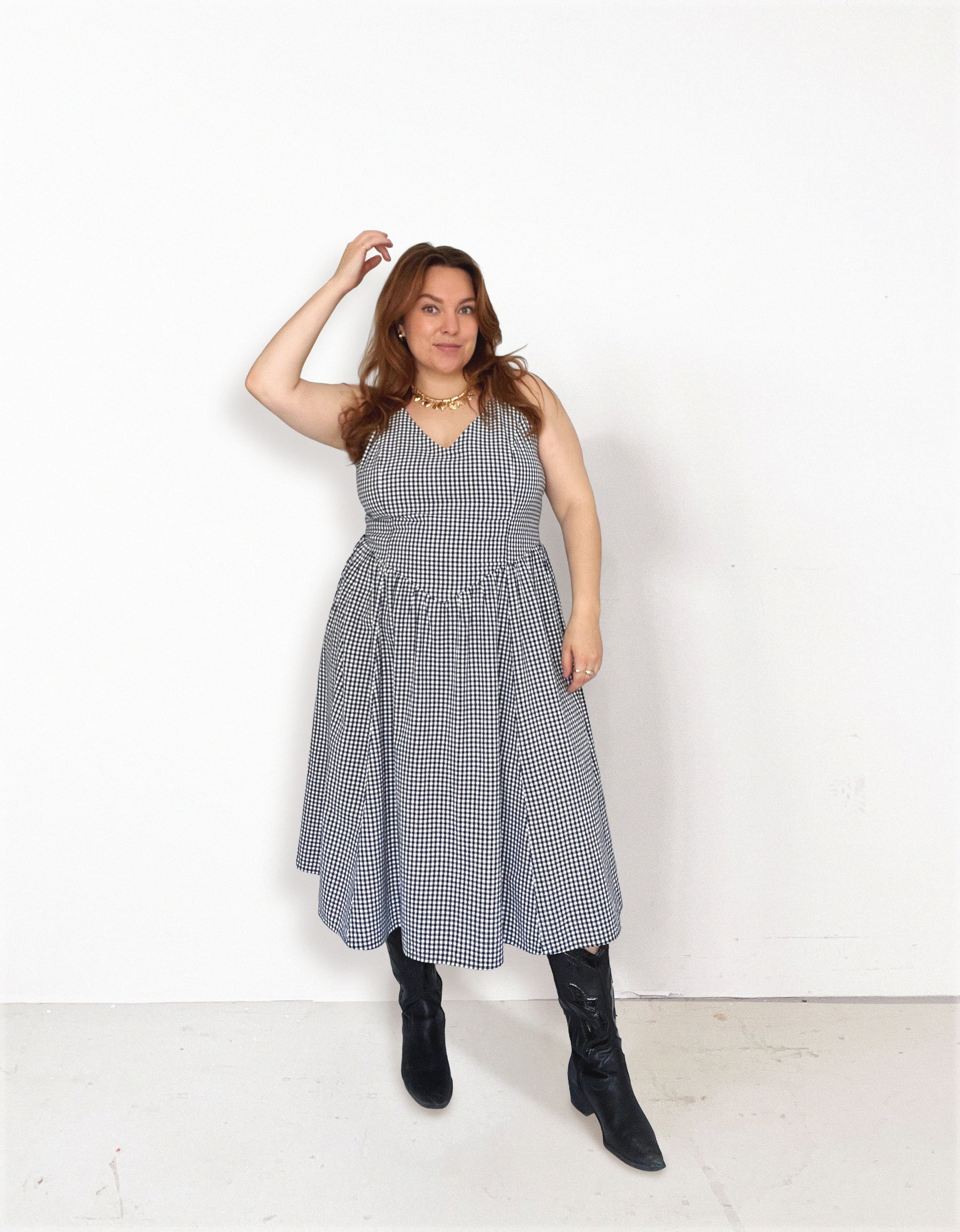 Woman wearing the Sailaway Dress sewing pattern from Les Perlines on The Fold Line. A dress pattern made in rayon, viscose, cotton, linen, or tencel twill fabric, featuring a V-neckline, open back, lined bodice with princess seams, dropped waist, gathered skirt, and midi length. 
