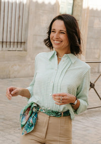 Woman wearing the Scala Shirt sewing pattern from Maison Fauve on The Fold Line. A shirt pattern made in poplin, crepe, voile, lace, lightweight denim, chambray, cotton, viscose, linen, tencel, or silk fabric, featuring a straight cut, slightly dropped shoulder, large pointed collar, topstitched front pleats, and long sleeves.