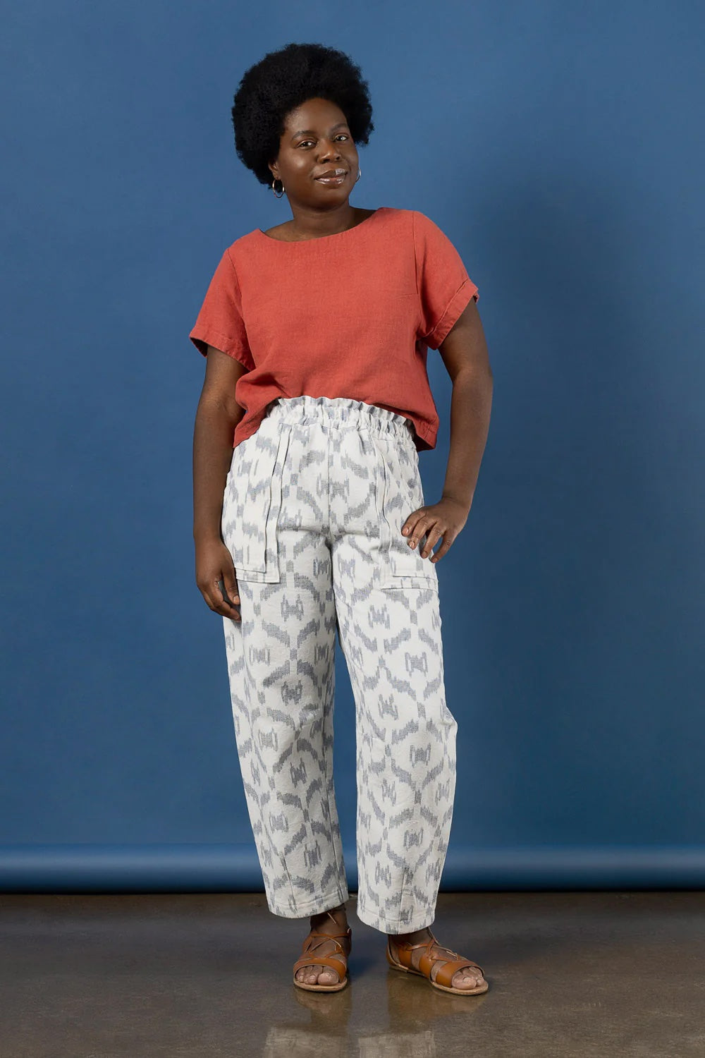 Woman wearing the Sepia Pants sewing pattern from Closet Core Patterns on The Fold Line. A trousers pattern made in linen, cotton ikat, chambray, broadcloth, lightweight denim, twill, or canvas fabric, featuring an elastic waistband with a paperbag edge, pockets, barrel leg, darts at the knee and hem, and ankle length.