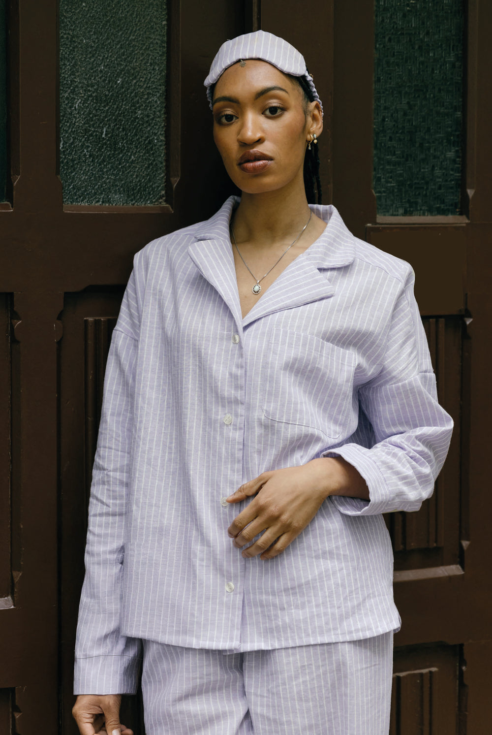 Woman wearing the Serena Pyjama Blouse sewing pattern from JULIANA MARTEJEVS on The Fold Line. A pyjama top pattern made in linen or cotton fabric, featuring a relaxed fit, lapel collar, and long sleeves with cuffs.