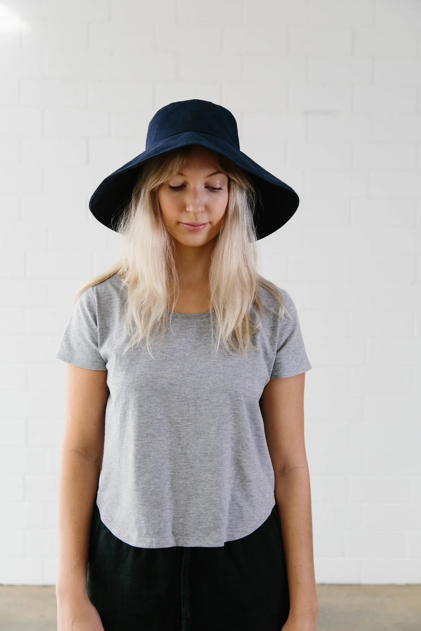 Woman wearing the Serpentine Hat sewing pattern from Elbe Textiles on The Fold Line. A hat pattern made in denim or canvas fabric, featuring a broad brim.